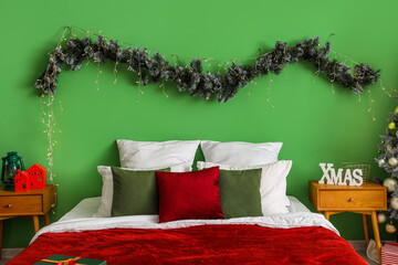 Interior of bedroom with bed, Christmas branches and tables