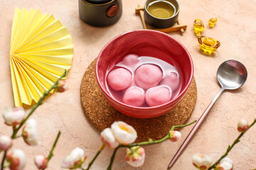 Bowl of tangyuan, Chinese decor and sakura on beige background. Dongzhi Festival