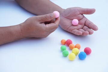Close up man hands holds small colorful plasticine dough balls. Concept, alzheimer, weak muscle patients recovering activity by sculpting. Make concentration. Develop imagination. 