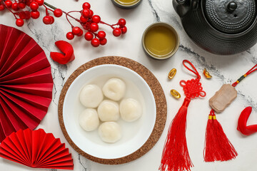 Bowl of tangyuan, Chinese decor, tea and fortune cookies on white marble background. Dongzhi...
