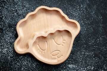 A plate for children in the shape of a lamb is made of wood for serving snacks, fruits, nuts, cheeses, meat and original serving of main dishes. Accessories for a modern kitchen.