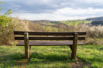 Fototapeta premium Bench on the hill with a view of the landscape in spring