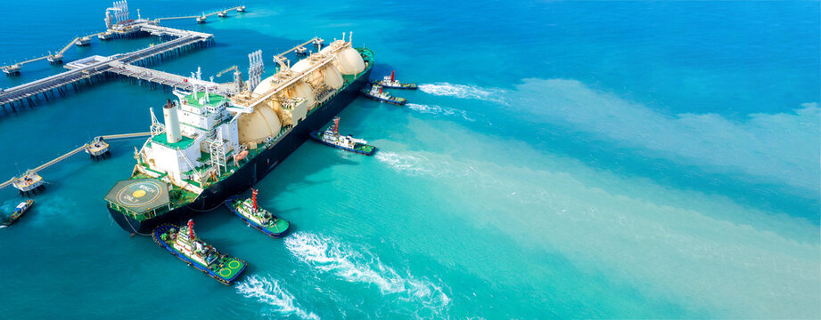 LNG (Liquefied natural gas) tanker anchored in Gas terminal gas tanks for storage. Oil Crude Gas Tanker Ship. LPG at Tanker Bay Petroleum Chemical or Methane freighter export import transportation.