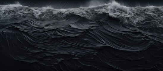 Bird's-eye view of waves on black Icelandic beach. - obrazy, fototapety, plakaty