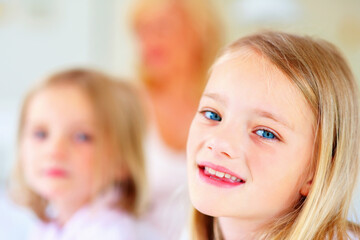 Happy, smile and portrait of sibling girls in home for bonding, love and cute relationship. Family, childhood sisters and face of young kids for playing, fun and relaxing in living room together