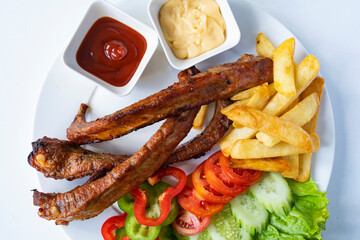Grill pork ribs with vegetables on white background.