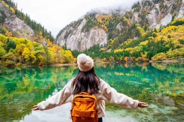 Foto op Plexiglas Young female tourist looking at beautiful autumn scenery landscape at jiuzhaigou national park in Sichuan, China © Kittiphan