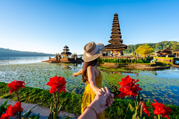 Young couple tourist relaxing and enjoying the beautiful view at Ulun Danu Beratan temple in Bali, Indonesia