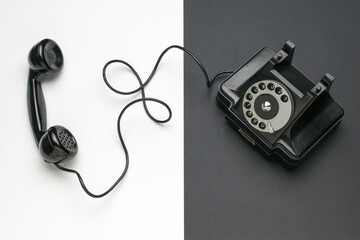 A black retro phone on a black and white background.