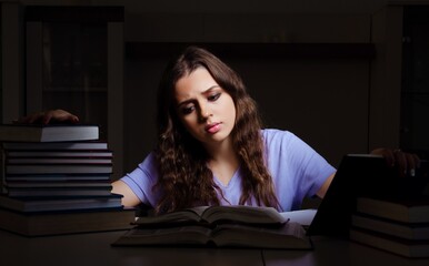 Young female student preparing for exams late at home