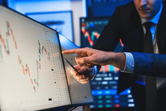 Stock traders pointing highest stock market on dynamic valued analysis on monitor real time screen, cooperating business investment in financial company to plan successful stock exchange. Sellable.