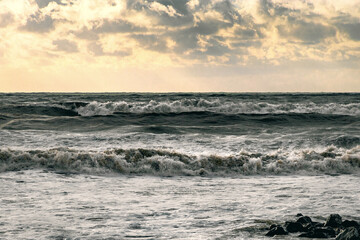 Beautiful sea waves during a storm. The Black Sea in a storm. Waves during a storm at sea. An epic seascape. Big waves crashing on the shore under a cloudy sky. View of the stormy seascape.