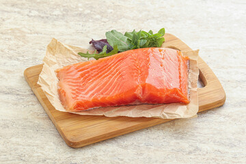 Raw salmon fillet over board