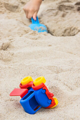 Fototapeta na wymiar Little boy with children toys on sand at beach. Relax or playing in summer. Vacation time
