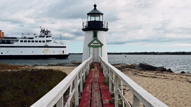 Steam Boat Ferry passing at Sunrise at Brant Point Lighthouse, Nantucket Island, Massachusetts, USA