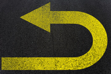 Flèche jaune demi tour sur asphalte 
