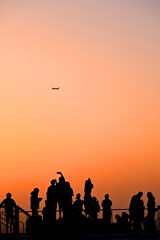 silhouette tourist group watching gold lighting sunset or sunrise sky background on skyscaper...
