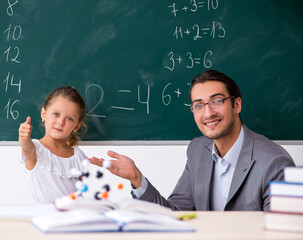 Teacher with young girl in the classroom