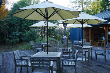 Obraz premium Outdoor Patio Table and Chair under Sunshade Umbrella, Image of Cafe Outside - 屋外 テーブルと椅子