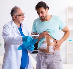 Injured young man visiting experienced male doctor