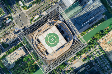Helipad on the rooftop of the modern skyscraper. Glass business offices district. Aerial drone view of helipad on the roof of a skyscraper in downtown.