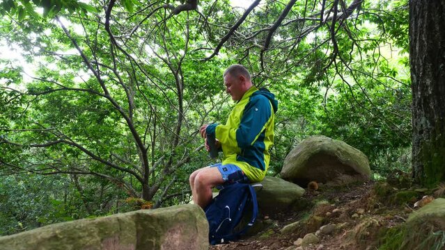 Mature man taking a break to hydrate during a hike on 'La Rhune' in the French Basque Country