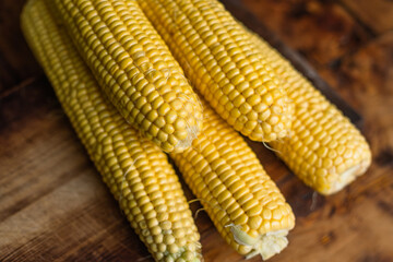 Ripe yellow corn cobs on rustic background.