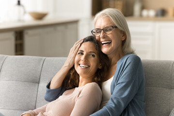 Happy blonde elderly mom and positive daughter woman enjoying close relationship, friendship,...