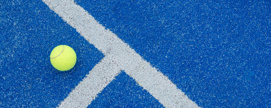 ball on a blue turf court paddle tennis court