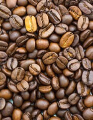 Obraz premium Close up of a bunch of coffee beans background top view; roasted dark brown coffe seeds