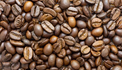 Fototapeta premium Close up of a bunch of coffee beans background top view; roasted dark brown coffe seeds