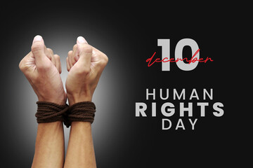A man's hands are tied with a rope with the text Human Rights Day. Concept of Human Rights Day on 10 December.