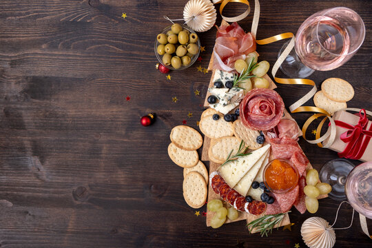 Charcuterie board italian food antipasti prosciutto ham, salami and cheese appetizers served in the shape of a Christmas tree. party food for New Year's Eve and Christmas