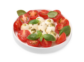Plate of tasty Caprese salad with mozzarella, tomatoes, basil and pesto sauce isolated on white