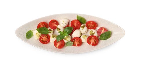 Plate of tasty Caprese salad with mozzarella, tomatoes, basil and pesto sauce isolated on white, top view