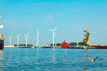 A seaport on the outskirts of Amsterdam with wind generators on the coast and solar panels mounted...