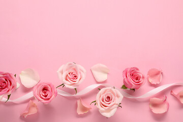 Beautiful roses, petals and ribbon on pink background, top view. Space for text