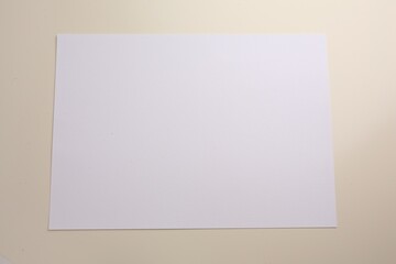 Sheet of parchment paper on beige background, top view