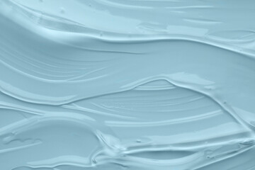 Clear cosmetic gel on light blue background, top view