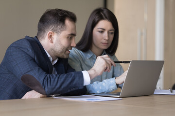 Financial advisor consulting bank client at formal meeting, look at laptop screen, review online presentation, sales manager make commercial offer to customer. Teamwork, workflow use modern tech app