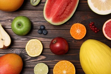 Different ripe fruits and berries on wooden table, flat lay