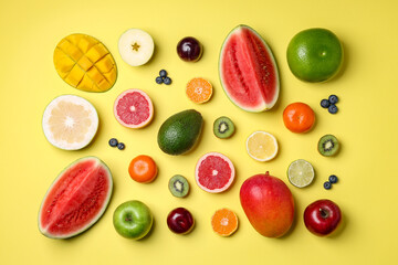 Different ripe fruits on yellow background, flat lay