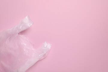 One plastic bag on pink background, top view. Space for text