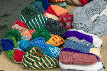 Colorful wool knitted socks for children handmade for the cold season. Things made of natural yarn. Winter clothes made of natural wool.  Knitting with needles.
