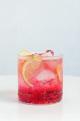Fancy iced berry lemon soda drink with sprinkle, festive drink for Christmas on white table.