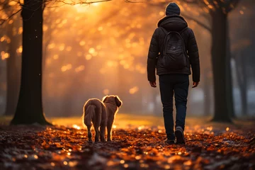 Foto op Canvas Man walking with dog in park at sunset. © valentyn640