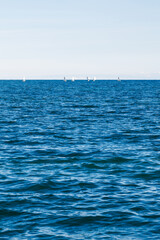 group of sailing boats on Issyk-Kul lake in Kyrgyzstan at sunny autumn afternoon