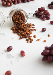 Brown dried sweet raisins in glass jar on light background.Macro
