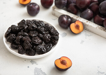 Plate with dried sweet prunes with ripe plums in wooden box.Macro.