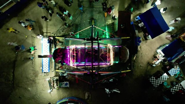 Establish aerial top view visitors ride the galeon alias kora-kora rides at the Padang city night market